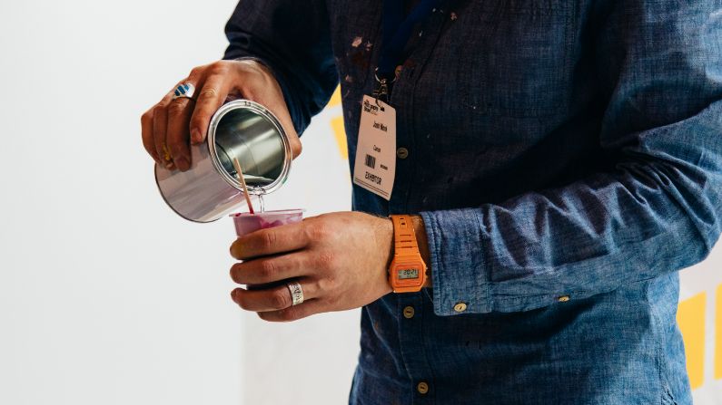 man wearing branded lanyard pouring hot drink