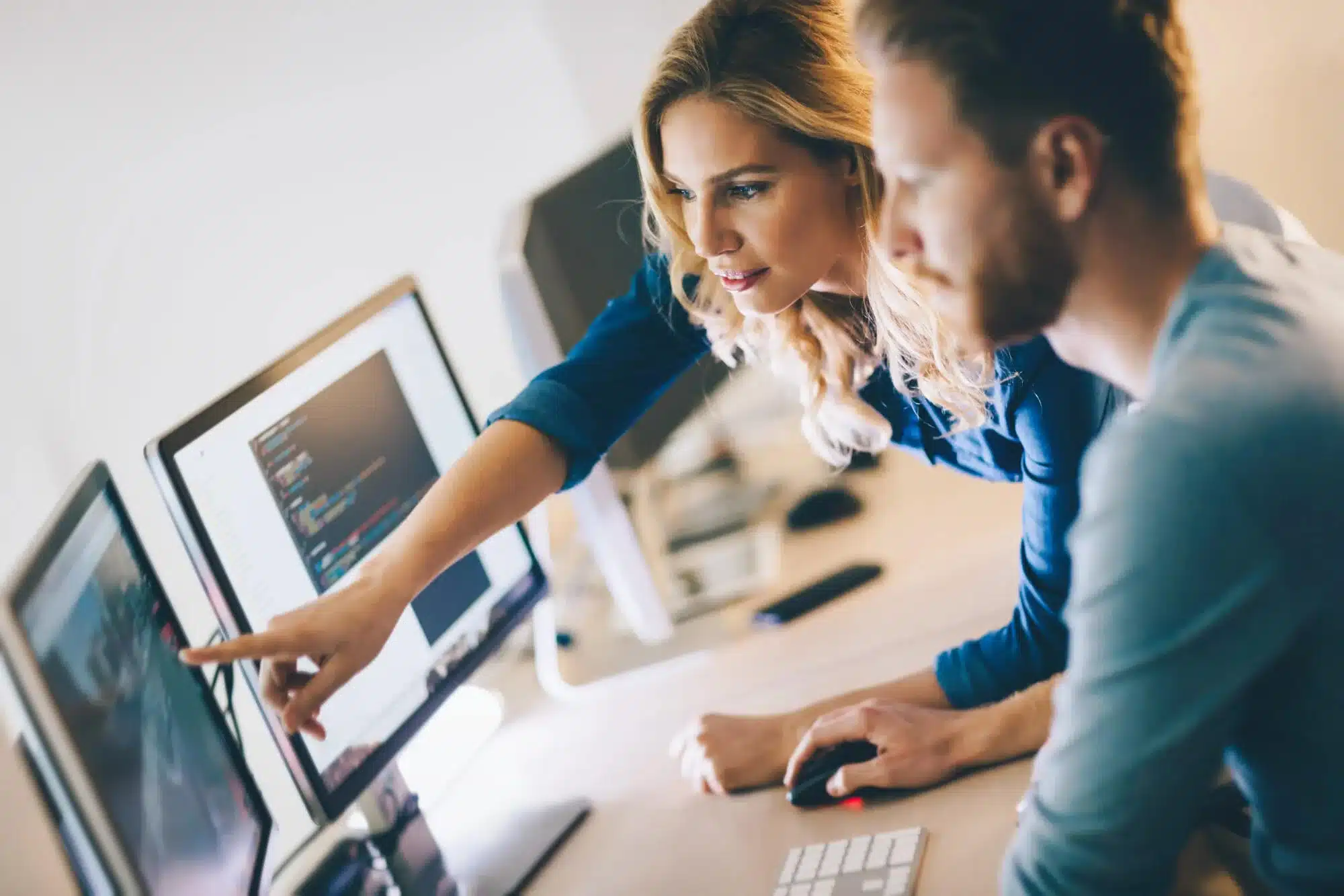 tech employees discussing branded merchandise whilst looking at a computer screen